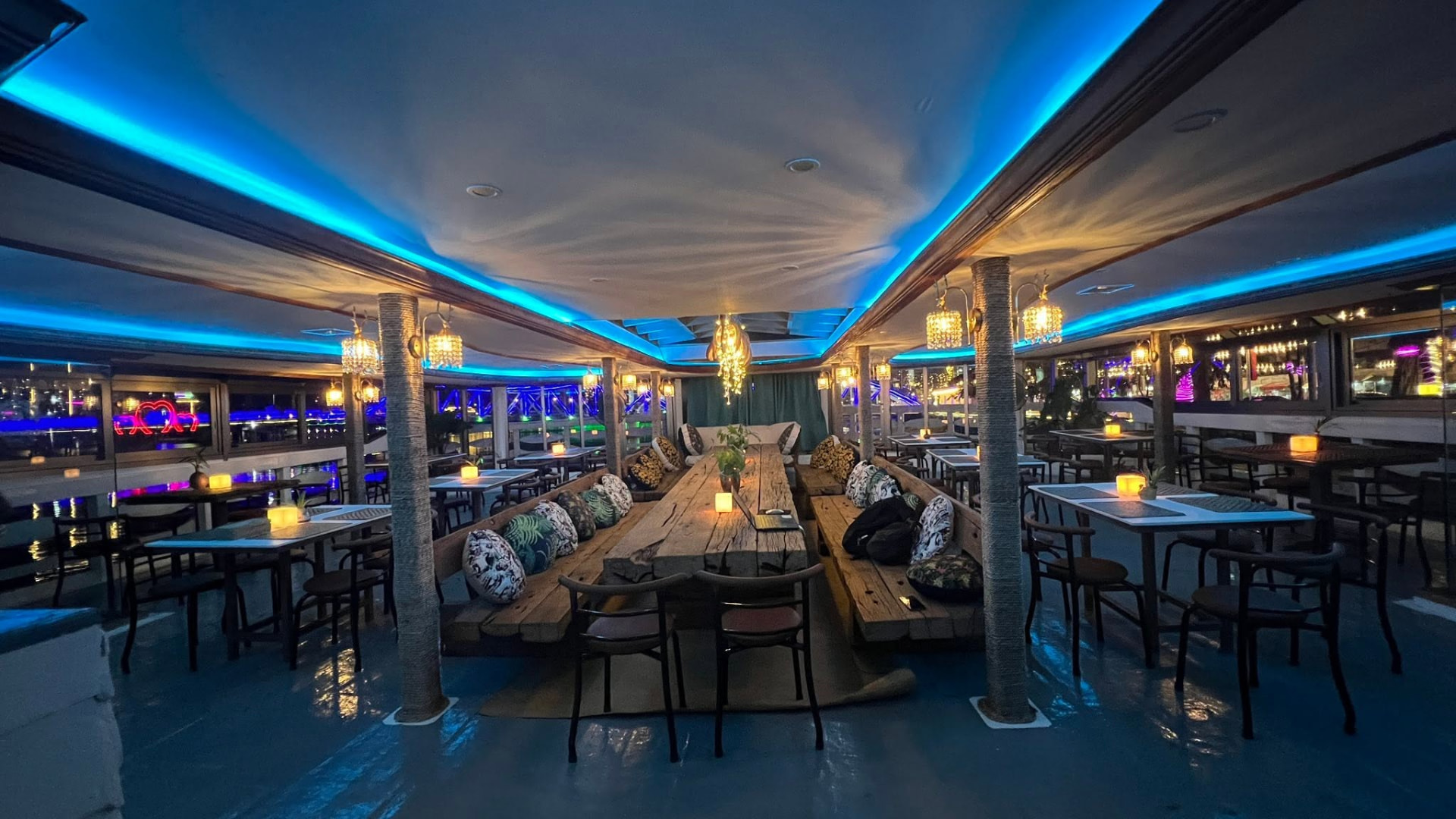 The Kdam Kampot boat dining room with bamboo lanterns, long timber table and river views